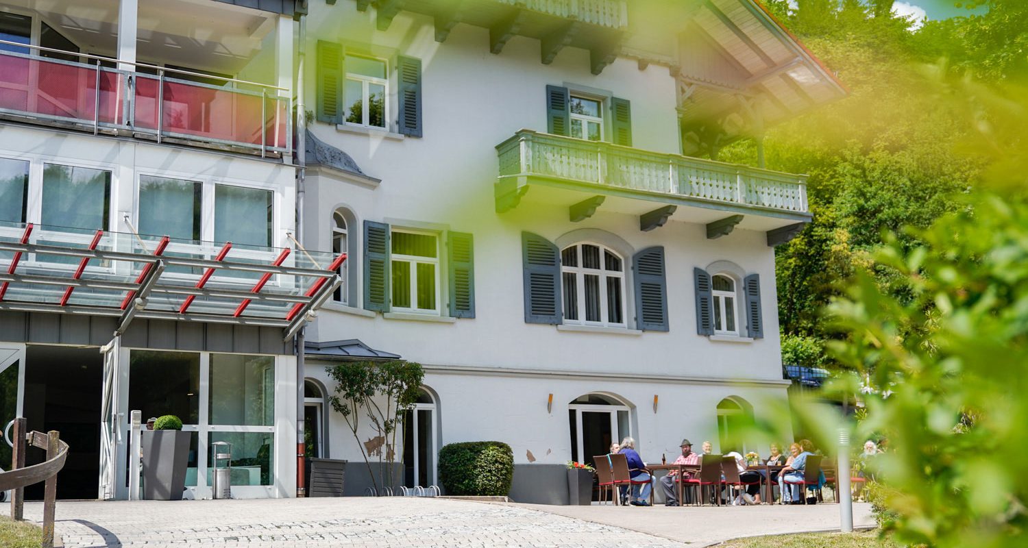 alwo_rupprechtstegen_beschuetzte-plaetze Das Haus Rupprechtstegen von außen während im Hof Bewohner gemeinsam sich unterhalten